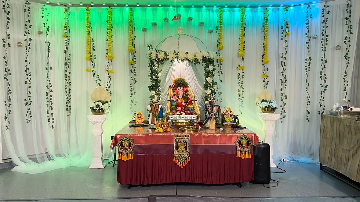 Ganesha idol with floral backdrop and hanging garlands